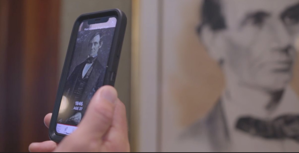 A guest points a phone at a portrait of Abraham Lincoln at the Willard and sees an 1846 photograph of him at age 37